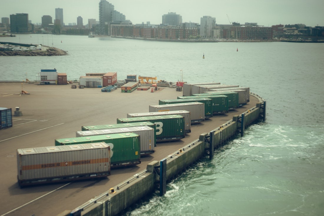 Shipping containers lined along a pier at a coastal port